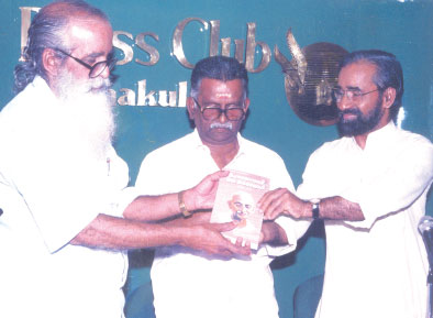 Dr. N. Radhakrishnan is releasing the Malayalam translation of the book Life Of Mahatma Gandhi authored by Louis Fisher by presenting the first copy to C. Uthama Kuruppu.